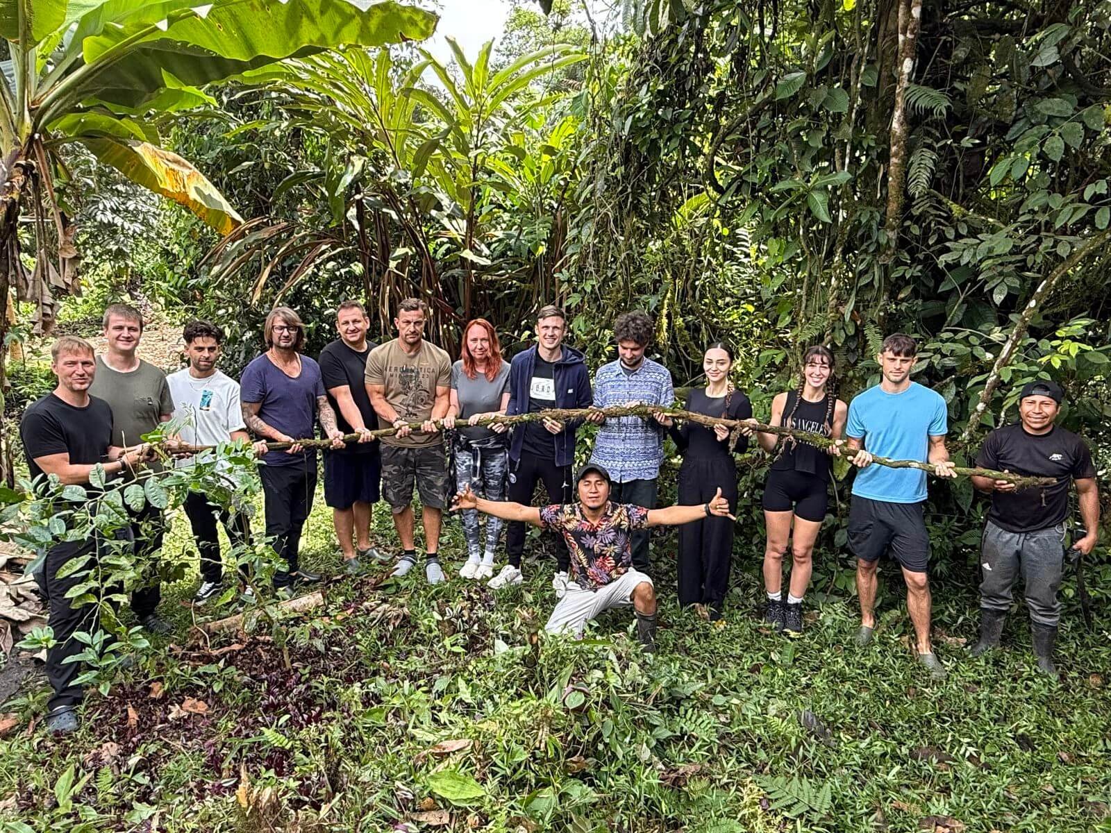 Participantes del retiro Feather Crown sosteniendo lianas de ayahuasca cosechadas.