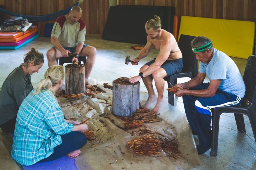 Los participantes del retiro preparan ayahuasca con el curandero kichwa Don Carlos.